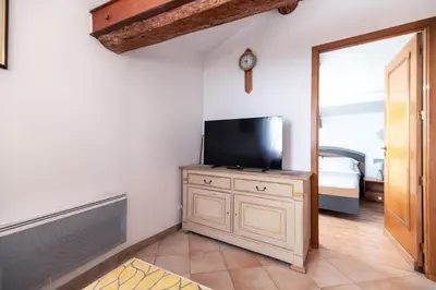 a room with a tv on a dresser with a door at Studio du couvent in Narbonne