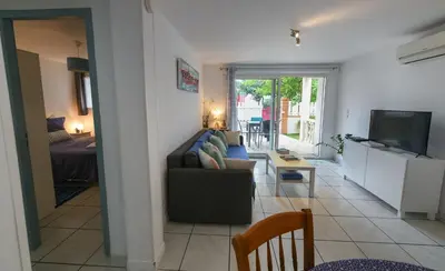 a living room with a couch and a television at La Belle Gruissanaise in Gruissan