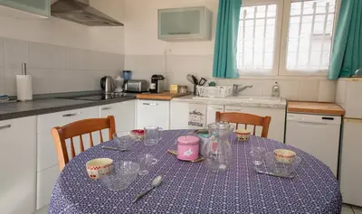 a kitchen with a table with a blue table cloth at La Belle Gruissanaise in Gruissan