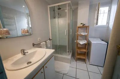 a bathroom with a sink and a glass shower at La Belle Gruissanaise in Gruissan