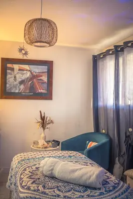 a bedroom with a bed and a blue chair at La Belle Gruissanaise in Gruissan