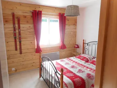 a bedroom with a bed and a window with red curtains at Toupinat in Montferrier