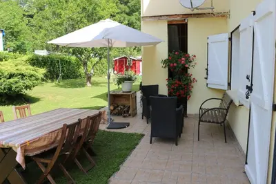 a patio with an umbrella and a table and chairs at Toupinat in Montferrier