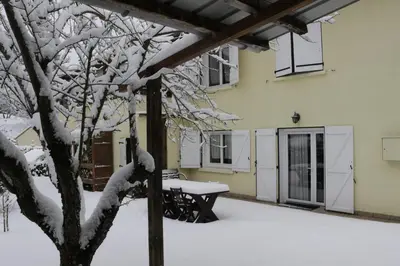a snow covered patio with a table and a tree at Toupinat in Montferrier
