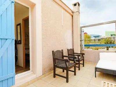 a pair of chairs sitting on the balcony of a house at CE12 Pavillon 3 pièces 6 couchages proche plage du Grazel - FR-1-409-70 in Gruissan
