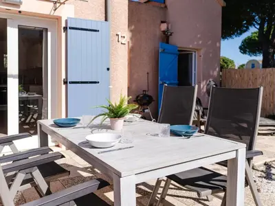 a wooden table with bowls on it on a patio at CE12 Pavillon 3 pièces 6 couchages proche plage du Grazel - FR-1-409-70 in Gruissan
