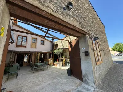 a building with a patio with a table and chairs at Casa Cessenon in Cessenon