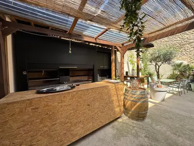 an outdoor kitchen with a large entertainment center at Casa Cessenon in Cessenon