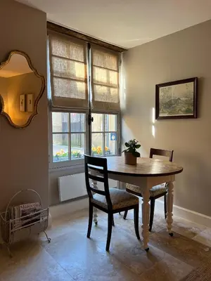a dining room with a wooden table and two chairs at Maison Marie in Lagarde