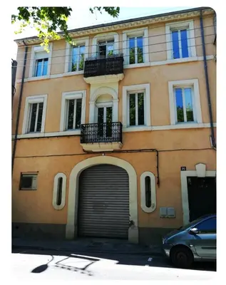 a building with a garage door in front of it at Appartement avec Terrasse in Narbonne