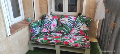 a couch sitting on a porch next to a window at Appartement avec Terrasse in Narbonne
