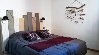 a bedroom with a bed and a clock on the wall at Appartement avec Terrasse in Narbonne