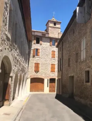 an alley in an old building with a tower at Chambre du couvent in Narbonne