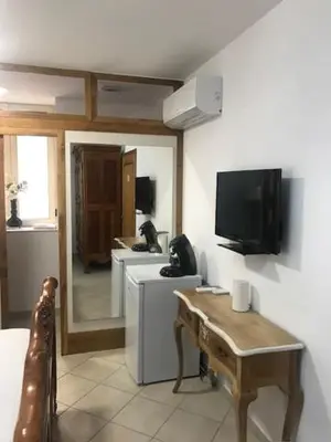 a living room with a television and a table at Chambre du couvent in Narbonne