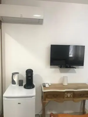 a room with a desk and a television on a wall at Chambre du couvent in Narbonne