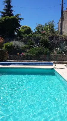 a swimming pool with blue water in a yard at Maison du Charron in Azillanet