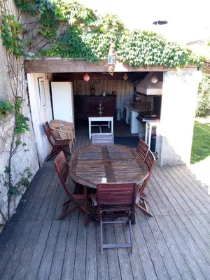 a wooden table and chairs on a deck at Maison du Charron in Azillanet