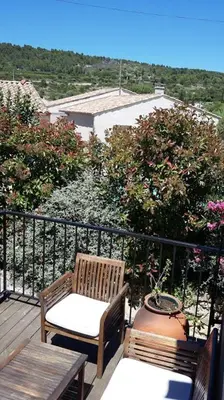a balcony with two chairs and a table and a view at Maison du Charron in Azillanet