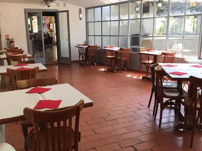 a restaurant with tables and chairs with red napkins on them at La Rapière in Carcassonne