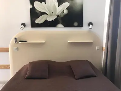 a bed with a picture of a flower on the wall at La Rapière in Carcassonne