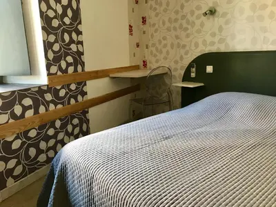 a bedroom with a bed with a black and white blanket at La Rapière in Carcassonne