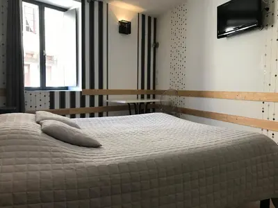 a bedroom with a bed with two pillows on it at La Rapière in Carcassonne