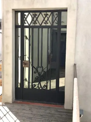 a black door with a metal gate on a building at La Rapière in Carcassonne