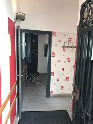 a hallway with a wall covered in red and white paper at La Rapière in Carcassonne
