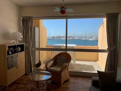 a living room with a window with a view of the water at EN BORD DE MER in Gruissan