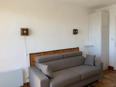 a couch sitting in a living room next to a wall at EN BORD DE MER in Gruissan