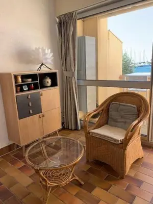 a living room with a chair and a glass table at EN BORD DE MER in Gruissan