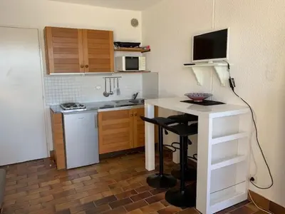 a small kitchen with a table and a counter top at EN BORD DE MER in Gruissan