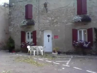 a building with a table and chairs in front of it at La maison des vendangeurs in Trausse