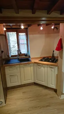 a kitchen with white cabinets and a sink and a window at La carole in Mosset