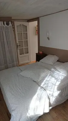 a bedroom with a large white bed and a window at La carole in Mosset