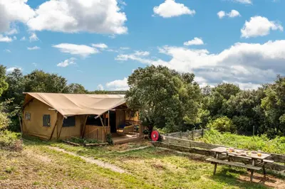 a large tent in a field with a picnic table at Glamping Tent Joy in Vélieux