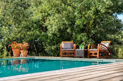 a group of chairs sitting next to a swimming pool at Glamping Tent Joy in Vélieux