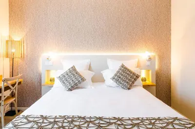 a bedroom with a large white bed with two pillows at Hôtel Le C - Boutique Hôtel in Narbonne
