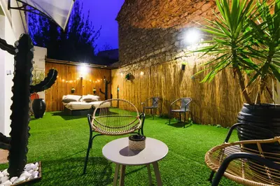 a garden with chairs and a table and a bed at Hôtel Le C - Boutique Hôtel in Narbonne