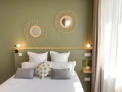 a bedroom with a bed with two mirrors on the wall at Hôtel Le C - Boutique Hôtel in Narbonne