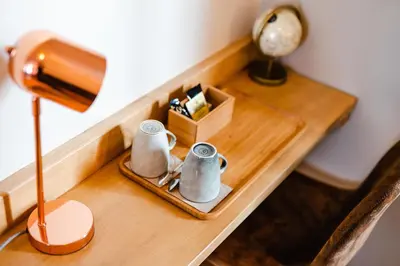 a table with two mugs on a table with a lamp at Hôtel Le C - Boutique Hôtel in Narbonne