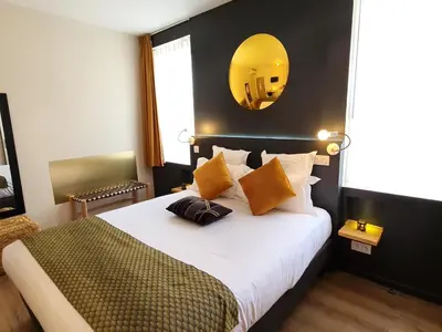 a bedroom with a large bed with a mirror on the wall at Hôtel Le C - Boutique Hôtel in Narbonne