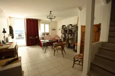 a living room with a table and chairs and a kitchen at la chambre claire in Sigean