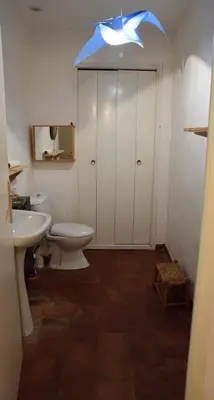 a bathroom with a toilet and a sink and a light at la chambre claire in Sigean