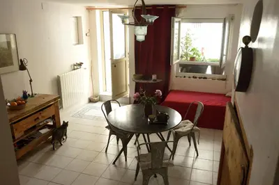 a living room with a table and chairs and a window at la chambre claire in Sigean