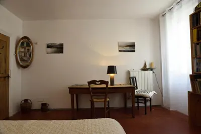 a room with a desk with two chairs and a lamp at la chambre claire in Sigean