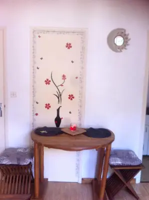 a table in a room with a wall with flowers at Studio confortable, Rennes les bains, 17 m² + Balcon in Rennes-les-Bains