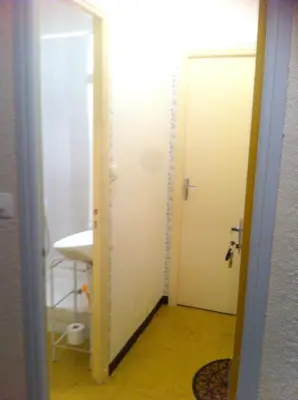 a bathroom with a white door and a sink at Studio confortable, Rennes les bains, 17 m² + Balcon in Rennes-les-Bains