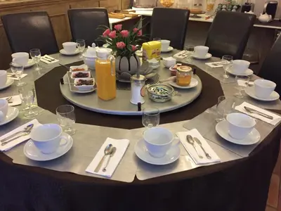 a table with plates and cups and saucers on it at Domaine Le Village in Villenouvelle