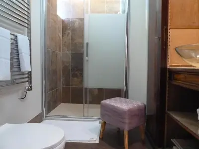 a bathroom with a shower with a toilet and a stool at Domaine Le Village in Villenouvelle